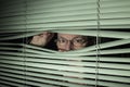 Man peeking through blinds Royalty Free Stock Photo
