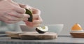 Man peel ripe avocado on kitchen countertop side view