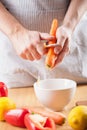 Man peeling carrot in kitchen