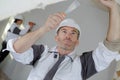 Man peeling ceiling with plaster spatula Royalty Free Stock Photo