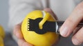 Man peeling fresh lemon with zester, closeup view