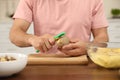 Man peeling potato at table, closeup. Preparing vegetable Royalty Free Stock Photo