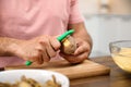 Man peeling potato at table, closeup. Preparing vegetable Royalty Free Stock Photo