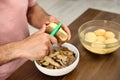 Man peeling potato at table, closeup. Preparing vegetable Royalty Free Stock Photo