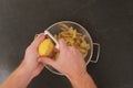 A man peels potatoes with a vegetable peeler. Preparation of potatoes for cooking. Cleaning the peel from pesticides. A
