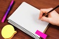 Man With Pen Writing Recent Updates On Notebook On Desk With Notes And Pencils. Businessman Presenting Important Message