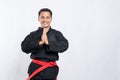 Man in pencak silat uniform poses respectfully with both hands cupped in front of his chest Royalty Free Stock Photo