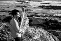 A man performer with a tuba on the seashore. Black and white photo. Royalty Free Stock Photo