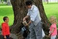 Man performing card tricks with young boy and girl in the park,Saratoga Springs,New York,2014