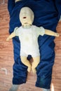 Man performing CPR on baby training doll dummy with one hand compression. First Aid Training - Cardiopulmonary resuscitation.