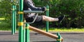 Man performing an exercise, on uneven bars, outdoors, side view Royalty Free Stock Photo