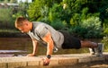 Man performing push ups by the river