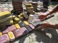A man, performing work on laying paving slabs, knocks on bright multicolored tiles with a rubber mallet