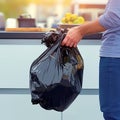 Man performs daily chore, removes garbage bag from kitchen can