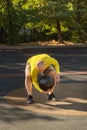 Man performs an exercise with a medicine ball on a street sports ground.