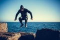 Man performs freerunning jump on stones Royalty Free Stock Photo