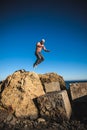 Man performs freerunning jump on stones Royalty Free Stock Photo