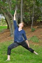 Man Performs Reverse Warrior Yoga Pose in Park