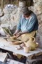 A man in period costume demonstrating the skill of pottery in th