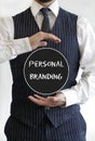 Man with a personal branding text on a black circle in the middle of his hands