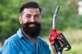 Man on petrol pump filling nozzles. Gas station. Portrait of bearded man hold fueling nozzle gasoline, fuel pump. Royalty Free Stock Photo