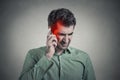 Man on the phone with headache. Cellular mobile radiation concept Royalty Free Stock Photo