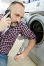 man on phone next to washing machine Royalty Free Stock Photo