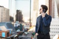 A man on the phone: strategical phone call on the balcony overlooking busy financial city center.