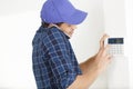 man on phone works on temperature thermostat Royalty Free Stock Photo