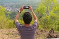 Man photographed mountains in the smartphone. A young man takes pictures of a volcano with a mobile phone. Indonesian teenager