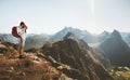 Man photographer with backpack and camera taking photo of aerial mountains landscape Royalty Free Stock Photo