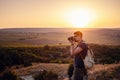 Man photographer with backpack and camera taking photo of sunset mountains Royalty Free Stock Photo