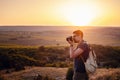 Man photographer with backpack and camera taking photo of sunset mountains Royalty Free Stock Photo