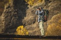 Man photographer with big backpack and camera taking photo of sunset mountains. Royalty Free Stock Photo