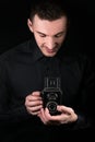 Man photographer holding a camera. Shooting process. Retro photo camera medium format twin-lens reflex camera on a black Royalty Free Stock Photo