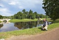 Man the photographer with a photocamera on a tripod on the bank of the lake Royalty Free Stock Photo