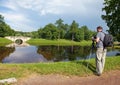 The man the photographer with a photocamera on a tripod on the bank of the lake Royalty Free Stock Photo