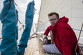 A man - a photographer in a red jacket and glasses sits on the d