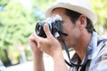 Man photographer with retro camera shooting outdoors