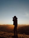 A man photographer taking pictures in front of autumn mountains landscape Royalty Free Stock Photo