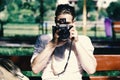 Man photographer. Young traveller or photographer sits on bench near backpack.