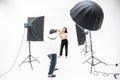 A man photographers are shooting pretty women in the studio with lighting equipment,