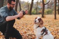 Man photographing his dog in a park. Royalty Free Stock Photo