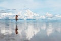 Man photographing ocean. Reflections of clouds on the water surface