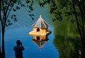 Man photographing small wooden birdhouse in the middle of a lake Royalty Free Stock Photo