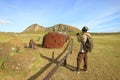 Man Photographing the Top Knots or Hat of Moai Statue Displaying on the Ground at Ahu Tongariki, Easter Island, Chile Royalty Free Stock Photo