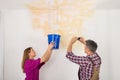 Man Photographing While Woman Collecting Water From Ceiling Royalty Free Stock Photo