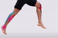 Man With Physio Tape Running Over White Background