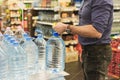 Man pick gallon bottle of drinking or distilling water at the shopping store