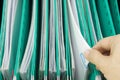 Man pick paperwork from green suspension folder hang in cabinet